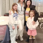 Happy reborn doll enthusiast Annie Klein and her family meeting internationally acclaimed full body silicone reborn doll artist Joanna Kazmierzak Pietka at an international doll show